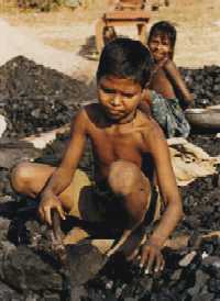  Two children breaking coal at a brick kiln 