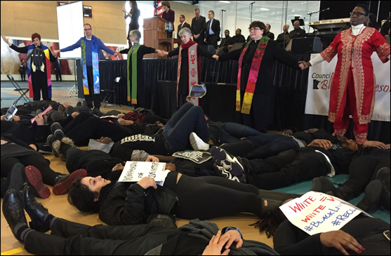 Twin Cities–area UU ministers join interfaith colleagues to form a prayer circle around young adults staging a Black Lives Matter die-in at Macalester College on Martin Luther King Jr. Day. The City of Bloomington, Minnesota, is pressing charges against the same activist group for a December 20 protest inside the Mall of America.