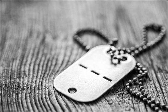 Old blank dog tag with chain on wooden background.